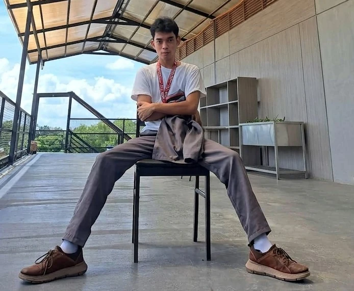 Prince Edrian Casem sitting on a chair under a covered walkway